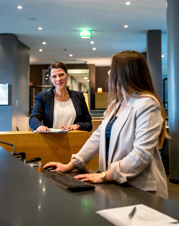 Hotel manager in conversation with an employee at reception