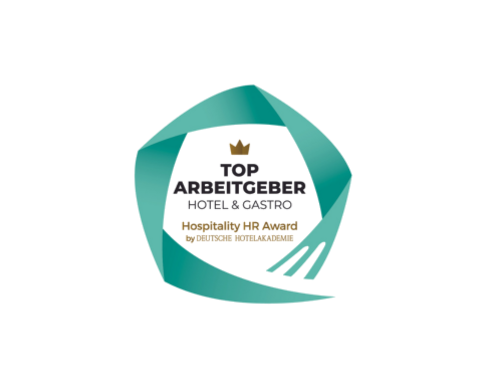 The green, circle-like logo features the words "TOP ARBEITGEBER Hospitality HR Award" in a circle. A crown is depicted above "Top."