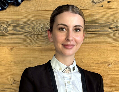 Nadja Karrer (Restaurant Supervisor, Severin*s – The Alpine Retreat) sitzt an einem Tisch mit einer Tasse Kaffee