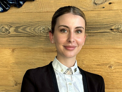 Nadja Karrer (Restaurant Supervisor, Severin*s – The Alpine Retreat) sitzt an einem Tisch mit einer Tasse Kaffee