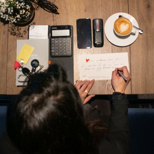 Blick von oben auf den Tisch mit zwei Kaffee an dem Duygu Saltik (Stellv. Hoteldirektorin, ATLANTIC Hotel Münster) sitzt