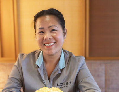 Nikka Vollstädt (breakfast service, LOUIS Hotel Munich) sits at a table with a cup of coffee