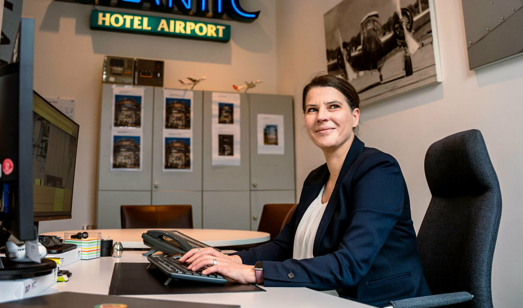 Hotel manager sits at her desk and looks to the side