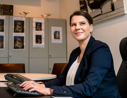 Hotel manager sits at her desk and looks to the side