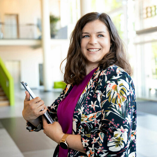 Viktoria Rathjen stands in the lobby of the hotel with a clipboard