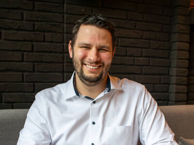 Romano Endres (Stellv. Restaurantleiter, ATLANTIC Hotel Landgut Horn) sitzt an einem Tisch mit einer Tasse Kaffee